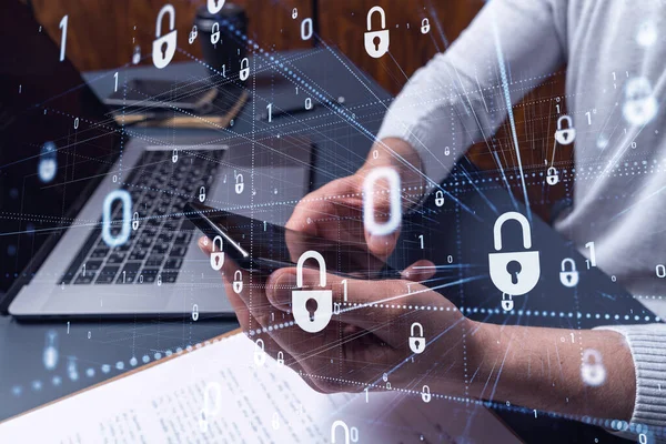 En programmør surfer på internettet i smartphone for at beskytte en cybersikkerhed fra hackerangreb og gemme klienter fortrolige data. Padlock Hologram ikoner over skrive hænder. - Stock-foto