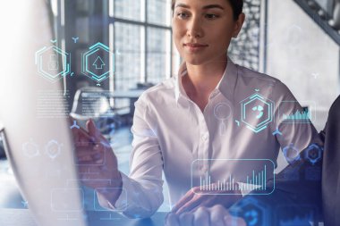 Resmi olarak çalışan iki meslektaş, yeni teknolojiler uygulayarak iş sürecini optimize etmek için birlikte çalışıyorlar. Modern ofis arka planında panoramik pencereli Hi Tech hologramları