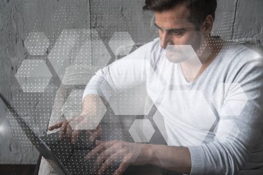 Dünya 'yı daha iyi bir yer haline getirecek yeni teknolojiler geliştirmek için dizüstü bilgisayar kullanan ciddi bir beyaz yönetici. Çifte maruziyet. Soyut teknoloji hologramı.