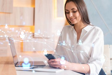 Beyaz gömlekli çekici bir iş kadını uluslararası iş danışmanlığı için yeni adayları kontrol etmek için akıllı telefon kullanıyor. Modern ofis geçmişi üzerinde HR ve sosyal medya simgeleri.