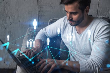 Yeni bir ağ geliştirmek için dizüstü bilgisayar kullanan ciddi bir Kafkasyalı yönetici. Çifte maruziyet. Sosyal medya hologramı.
