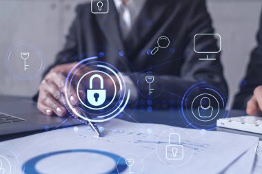 Uluslararası şirketin siber güvenliğini sağlamak için projede çalışan iki iş adamı ve kadın. Hologram simgelerini dokümanlarla masaya kilitle. Resmi kıyafet. Çalışma Alanı.