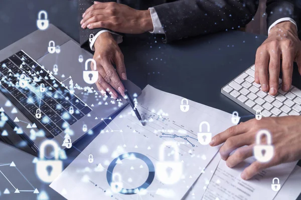 Dos hombres y mujeres de negocios que trabajan en el proyecto para proteger la ciberseguridad de la empresa internacional. Candado Iconos hologramas sobre la mesa con documentos. Ropa formal. Espacio de trabajo. — Foto de Stock