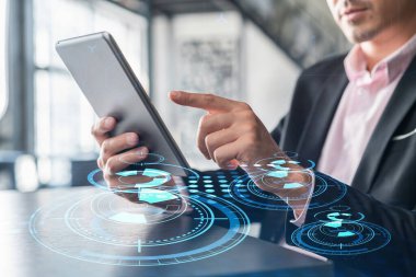 Businessman in suit using tablet device to optimize development by implying new technologies in business process. Interconnections and hi tech hologram over modern panoramic office background clipart