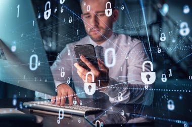 Sıradan giyinen bir iş adamı müşterileri gizli bilgilerini korumak için akıllı telefon kullanarak siber güvenliği kontrol ediyor. IT hologramı, modern ofis arkaplanının üzerine gece vakti simge kilitler.