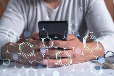 Programcı elinde akıllı bir telefon tutuyor ve tamamen yeni bir hizmet sunmak için yenilikçi bir uygulamayı test ediyor. Yakın çekim. Hologram teknik grafikleri. Dev takım kavramı.