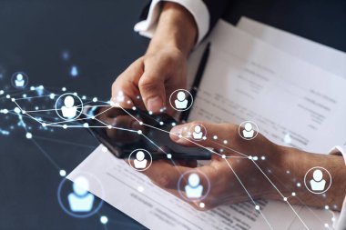 Potansiyel bir çalışan, kariyerini ilerletmek ve kişisel gelişimde yeni fırsatlar elde etmek için sözleşmeyi okurken resmi olarak giyiniyor. Akıllı telefondan anlaşmanın detaylarını kontrol ediyorum. Sosyal medya hologram simgeleri