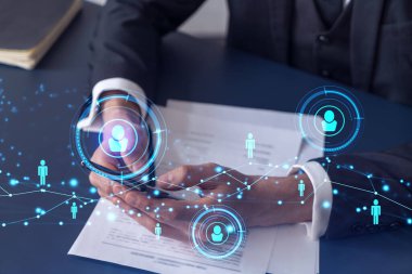 Potansiyel bir çalışan, kariyerini ilerletmek ve kişisel gelişimde yeni fırsatlar elde etmek için sözleşmeyi okurken resmi olarak giyiniyor. Akıllı telefondan anlaşmanın detaylarını kontrol ediyorum. Sosyal medya hologram simgeleri