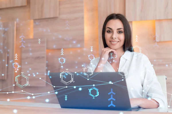 Attraktiv forretningskvinde i hvid skjorte på arbejdspladsen arbejder med laptop til at optimere udviklingen ved at antyde nye teknologier i forretningsprocessen. Hej tech hologram over kontor baggrund - Stock-foto