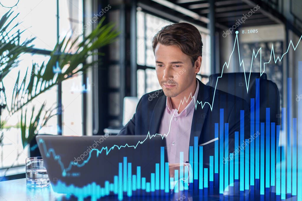 Handsome businessman in suit at workplace working with laptop to optimize trading strategy at corporate finance fund. Forex chart hologram over office background