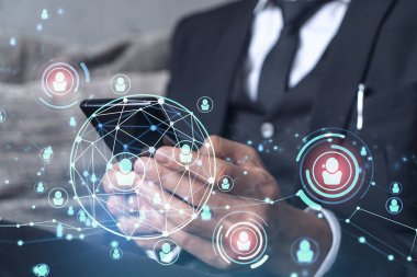 Uluslararası takımı işe alacak en iyi adayları bulmak için sosyal ağları akıllı telefonlarla tarayan insan kaynakları uzmanlarının elleri. Başarı kavramı. Medya hologram simgeleri. Resmi giysi.