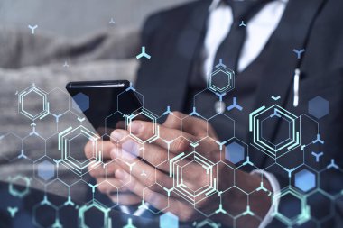 Programcı elinde akıllı bir telefon tutuyor ve tamamen yeni bir hizmet sunmak için yenilikçi bir uygulamayı test ediyor. Yakın çekim. Hologram teknik grafikleri. Dev takım kavramı. Resmi giysi.