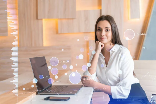 Attraktiv forretningskvinde i hvid skjorte på arbejdspladsen arbejder med laptop til at optimere handelsstrategi på corporate finance fond. Forex diagram hologram over kontor baggrund - Stock-foto