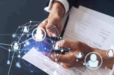 Potansiyel bir çalışan, kariyerini ilerletmek ve kişisel gelişimde yeni fırsatlar elde etmek için sözleşmeyi okurken resmi olarak giyiniyor. Akıllı telefondan anlaşmanın detaylarını kontrol ediyorum. Sosyal medya hologram simgeleri