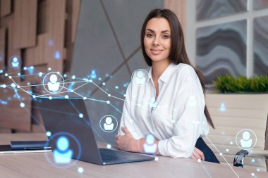 İş yerindeki beyaz gömlekli çekici iş kadını uluslararası iş danışmanlığı için yeni çalışanlar arıyor. İK ve sosyal medya hologram simgeleri ofis arka planında