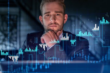 Resmi takım elbiseli yakışıklı iş adamının portresi kurumsal finans fonunda ticaret stratejisini nasıl optimize edeceğini düşünüyor. Modern ofis geçmişi üzerinde eski grafik hologramı. Eller çenede..