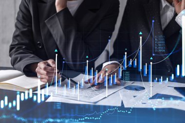 Borsa davranışlarını tahmin etmek için tarihi verileri araştıran iki tüccar. Ticaret dünyasındaki kadınlar. Belgenin olduğu masanın üzerinde eski ve finansal hologram şeması.
