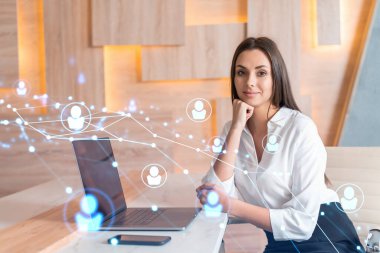 İş yerindeki beyaz gömlekli çekici iş kadını uluslararası iş danışmanlığı için yeni çalışanlar arıyor. İK ve sosyal medya hologram simgeleri ofis arka planında