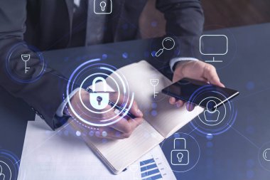 Programcı, müşterilerin siber güvenliği korsan saldırılarından korumak ve müşterilerinin gizli verilerini kaydetmek için gerekli notları alıyor. Akıllı telefon kullanmak. Asma kilit hologram simgeleri. Resmi giysi