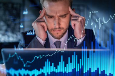 İş yerindeki takım elbiseli yakışıklı işadamı şirket finans fonundaki ticaret stratejisini optimize etmek için dizüstü bilgisayarla çalışıyor. Ofis arkaplanı üzerinde eski grafik hologramı