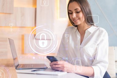 Beyaz gömlekli çekici bir iş kadını müşterileri korumak için siber güvenliği kontrol ediyor. IT hologramı modern ofis arkaplanının üzerine simgeleri kilitledi.