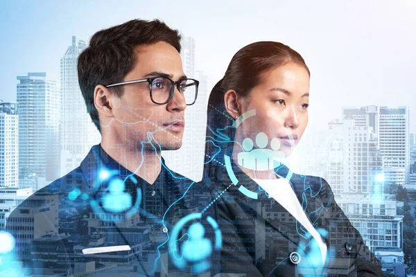 Businessman and businesswoman as a SMM specialists thinking about development of social media marketing strategy to achieve business goals. Hologram icons over Bangkok background. — Stock Photo, Image