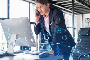 Takım elbiseli iş adamının, iş sürecinde yeni teknolojiler ima ederek gelişimi optimize etmek için konferans çağrısı var. Ofis arka planında panoramik pencereli yüksek teknoloji hologramı ve bağlantıları var