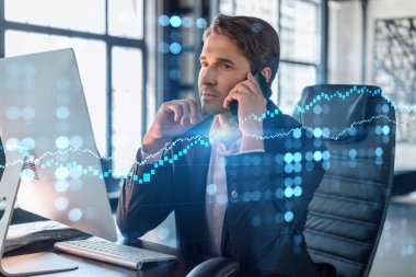 Takım elbiseli iş adamının şirket finans fonunda ticaret stratejisini optimize etmek için konferans görüşmesi var. Ofis arkaplanı üzerinde panoramik pencereli eski grafik hologramı