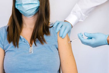 Mavi eldivenli tıbbi personel Coronavirus covid-19 aşısını enjekte ediyor.