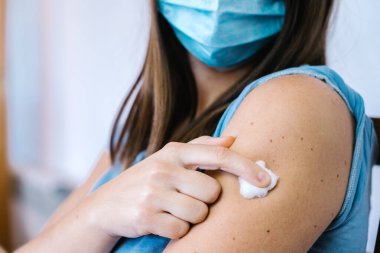 19 enjeksiyondan sonra kolunda pamuk tutan kadın.