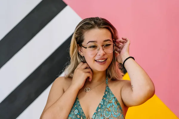 Blond meisje met bril poseren met kleurrijke achtergrond — Stockfoto
