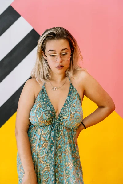 Blond meisje met bril poseren met kleurrijke achtergrond — Stockfoto