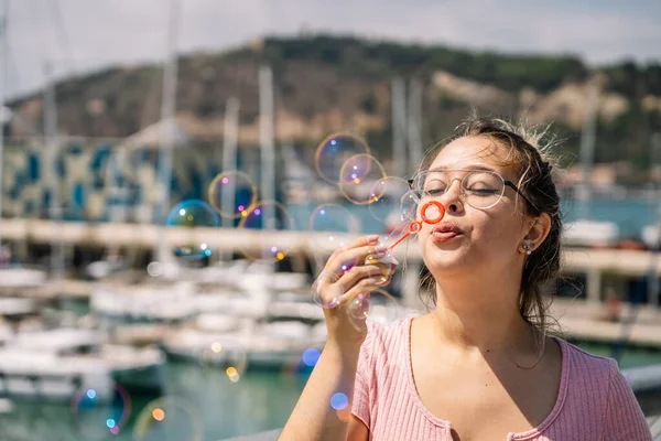 Young woman blows soap bubbles — Stock Photo, Image