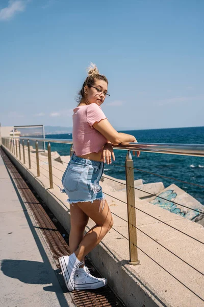 Jeune femme blonde pose devant la mer — Photo