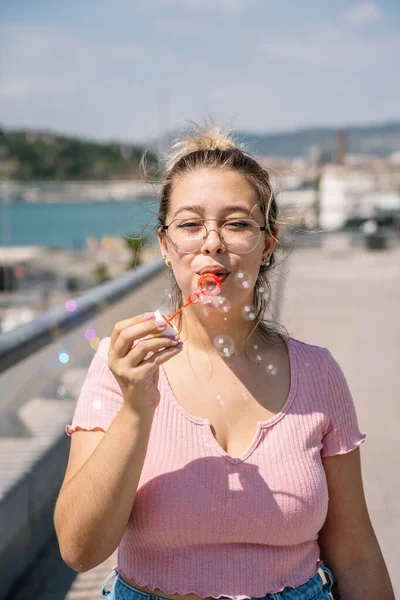 Jeune femme souffle des bulles de savon — Photo