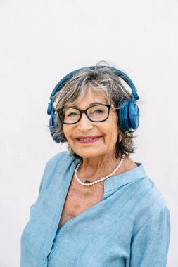 Müzikten hoşlanan yaşlı bir kadın, mutlu ve bağlı hissediyor.