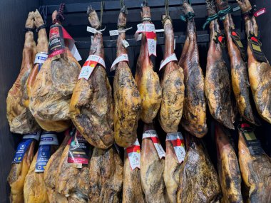 Bir şarküteride asılı duran iber jambonu bacakları, İspanya 'nın 1 Aralık 2025 Barselona şehrinde geleneksel yemek ve gastronomiyi temsil ediyor.