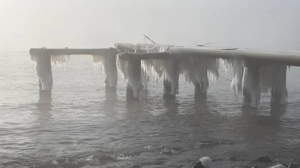 Kışın Karadeniz kıyısında terk edilmiş eski bir rıhtımda buz.