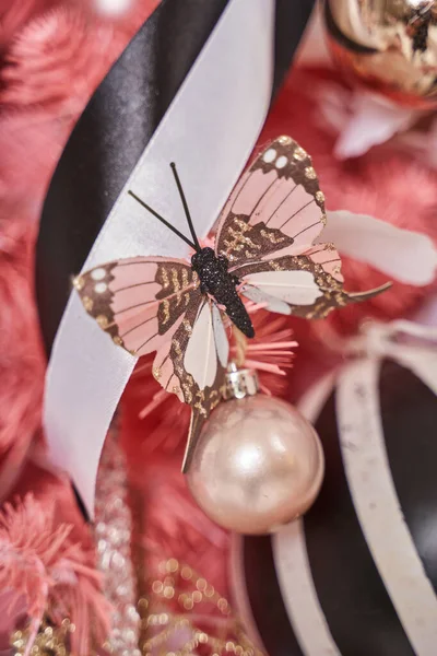 Noel ağacındaki güzel Noel süsleri: pembe kelebek, top ve kurdele