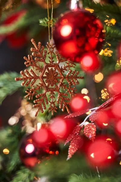 美しいボケのあるクリスマスツリーの美しい黄金の雪の結晶赤い果実と赤いボール — ストック写真