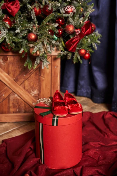 Noel ağacının altındaki küçük bir kız için hediye kutularının üzerinde kırmızı ayakkabılar.                                      