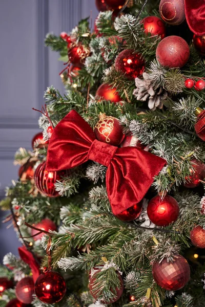 Büyük kırmızı kadife fiyonklu kırmızı toplarla süslenmiş güzel Noel ağacı.                               