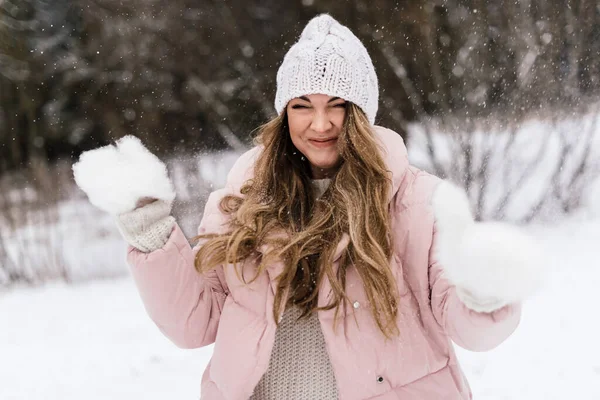 Gözünü kısarak bakan bir kızın komik bir canlı fotoğrafı. Çünkü yüzünde kar uçuşuyor.