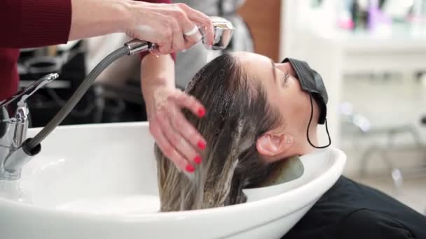 Tangan Penata Rambut Mencuci Busa Dari Rambut Panjang Pirang Basah — Stok Video