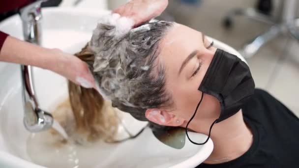 Una Chica Una Máscara Protectora Espuma Champú Sobre Cabello Mojado — Vídeo de stock