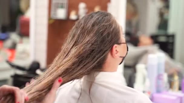 Парикмахер Наносит Укладку Руками Длинные Влажные Волосы Девушки Защитной Маске — стоковое видео