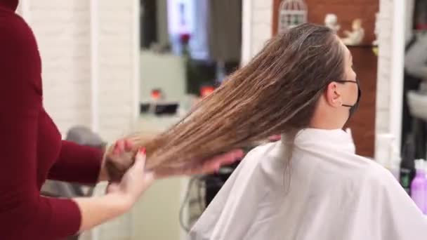 Mãos Cabeleireiro Aplicam Produto Styling Cabelo Longo Molhado Uma Menina — Vídeo de Stock