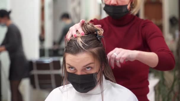 Penata Rambut Memotong Seorang Wanita Muda Dalam Topeng Pelindung Hitam — Stok Video
