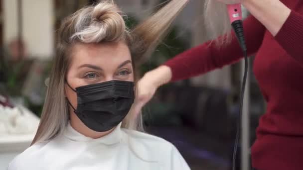 Dziewczyna Masce Patrzy Kamerę Podczas Gdy Jej Włosy Suszone Suszarką — Wideo stockowe