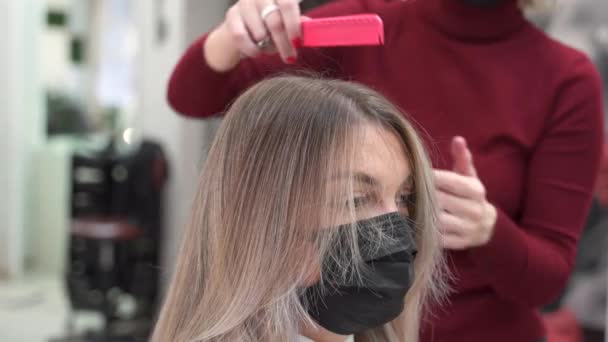 Μια Κοπέλα Μαύρη Μάσκα Κόβει Μαλλιά Της Ψαλίδι Και Χτενίζεται — Αρχείο Βίντεο
